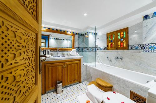 uma casa de banho com uma banheira, um WC e um lavatório. em Riad Rcif Alif Suite & SPA em Fez