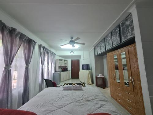1 dormitorio con 1 cama y ventilador de techo en Chantelle's Overnight Room, en Richards Bay