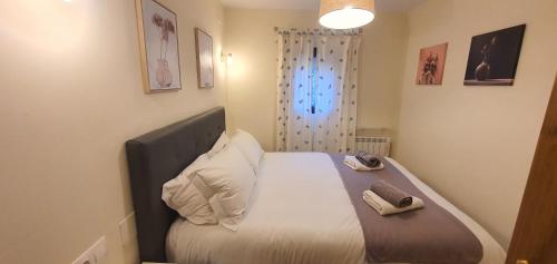 a small bedroom with a bed with white sheets at Slalom BG Sierra Nevada in Sierra Nevada