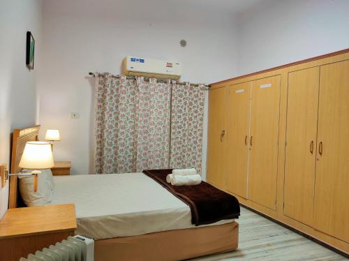 a bedroom with a bed and wooden cabinets at Homestay at Bungalow 97 Ajmer in Ajmer