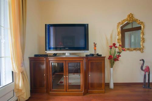 a tv sitting on top of a wooden entertainment center at Royal Holiday Apartments Sveti Stefan in Sveti Stefan