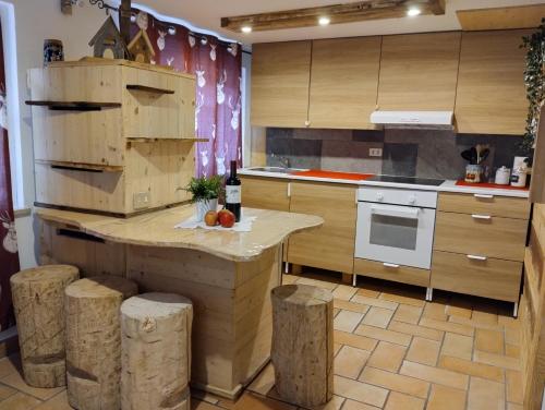 una cucina con sgabelli in legno e bancone in una stanza di Botton d'oro a Campitello di Fassa