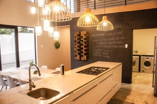 a kitchen with a sink and a counter with lights at Amabwe Guesthouse in Grahamstown