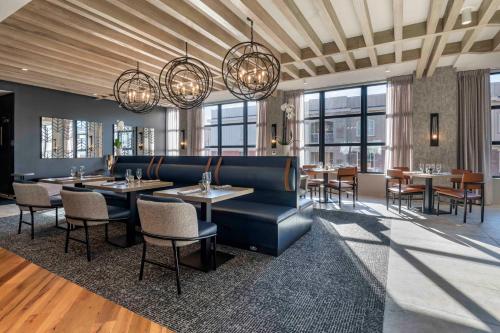a dining room with tables and chairs and windows at Cambria Hotel Portland Downtown Old Port in Portland