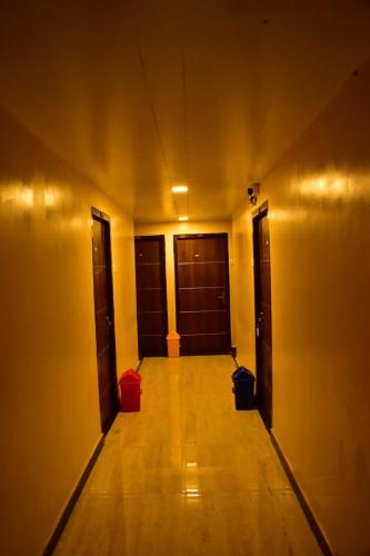 een lege hal met deuren en een houten vloer bij CHANDRA ROYAL RESIDENCY in Vellore