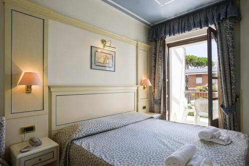 a bedroom with a bed and a large window at Hotel Poseidon in Terracina