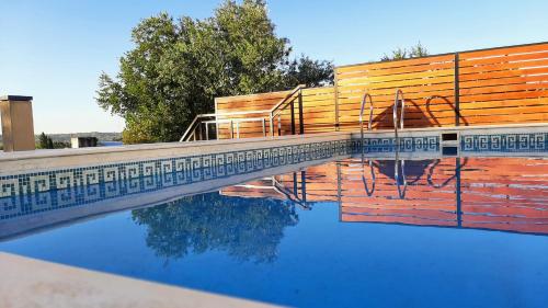 una piscina con una valla de madera y su reflejo en el agua en NIZA II - Planta Baja. Dto.C en Villa Carlos Paz