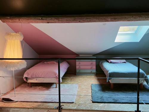 a attic room with two beds and a window at Dans les étoiles in Cuttura