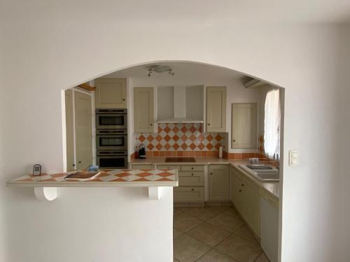 a kitchen with an archway in the middle of it at Les locations Cinaureva "Les Îles d'Or" in La Londe-les-Maures