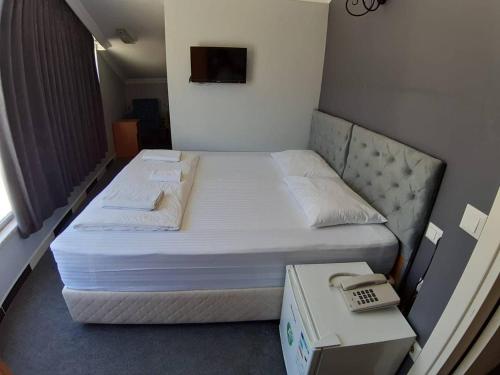 a bed in a room with a phone and a box at ZEMAHOTEL in Büyükçekmece