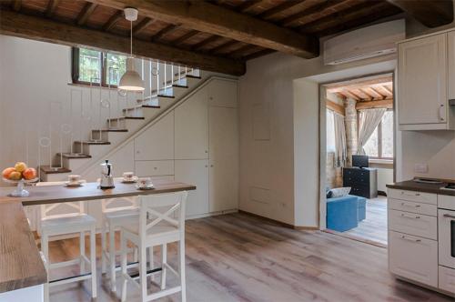 una cocina con mesa y una escalera en una casa en FAETOLE typical Tuscan country house near FLORENCE, en Capannuccia