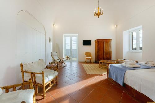 a bedroom with a bed and a chair and a tv at TORRETTA CORRICELLA- Punta Pizzaco in Procida