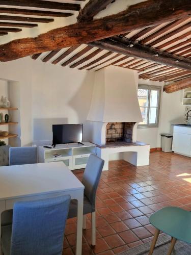 - un salon avec une table blanche et une cheminée dans l'établissement Les toits de Mignet, à Aix-en-Provence