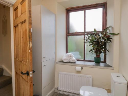 een badkamer met een toilet en een raam bij Kendal Cottage in Kendal