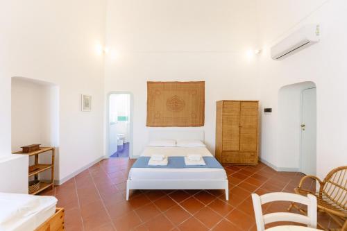 Habitación con cama, mesa y sillas. en TORRETTA CORRICELLA- Punta Serra, en Procida