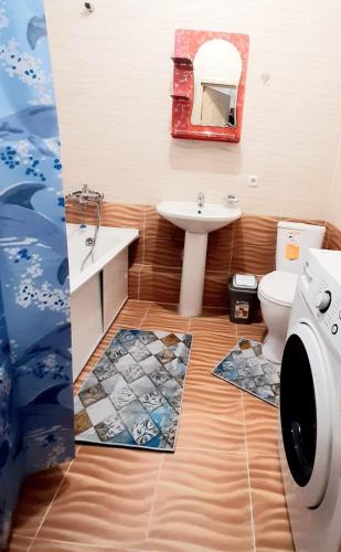 ein Badezimmer mit einem Waschbecken, einem WC und einem Spiegel in der Unterkunft Однокомнатная квартира в ЖК Сенатор, рядом с посольством США in Astana