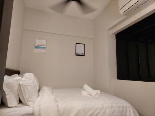 a bedroom with a bed with white sheets and a window at Batu Ferringhi Luxury Seaview Suite - 3Br in Batu Ferringhi