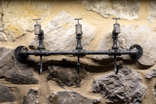 a black pipe is attached to a stone wall at Villa MYLOS Kalavrita in Kalavrita