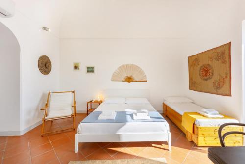 a room with two beds and a table and a chair at TORRETTA CORRICELLA- Punta dei Monaci in Procida