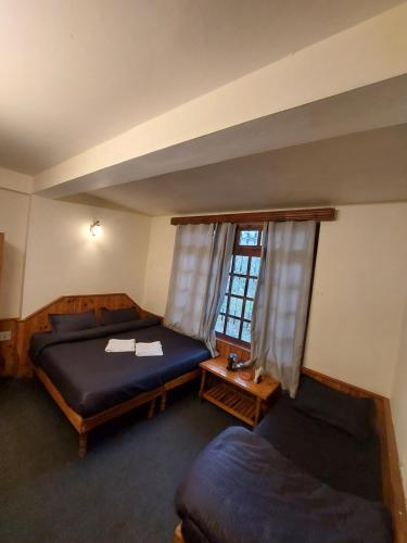 1 Schlafzimmer mit 2 Betten und einem Fenster in der Unterkunft Mars Monkey Hostel & Cafe in Manali