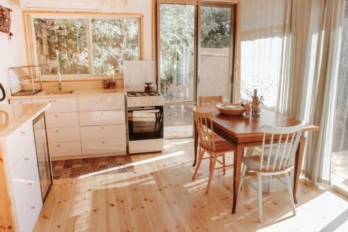 a kitchen with a wooden table and a table and chairs at Jasmine House in Amirim