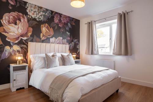 ein Schlafzimmer mit einem großen Bett mit Blumentapete in der Unterkunft Modern 3 bedroom spacious house with parking in Bath