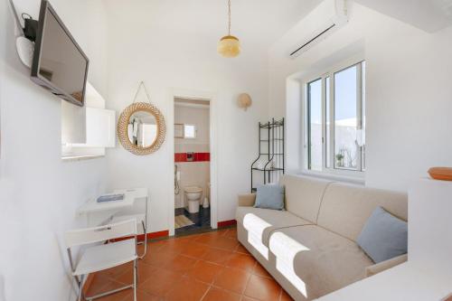 ein Wohnzimmer mit einem Sofa und einem TV in der Unterkunft TORRETTA CORRICELLA- Torretta in Procida