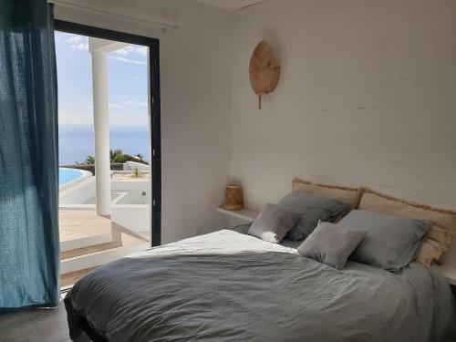 um quarto com uma cama e vista para o oceano em Villa romantique, Rêve d'ailleurs, saint leu, la Réunion em Saint-Leu