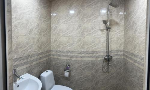 a bathroom with a shower with a toilet and a sink at Hotel KA-EL in Musalerr