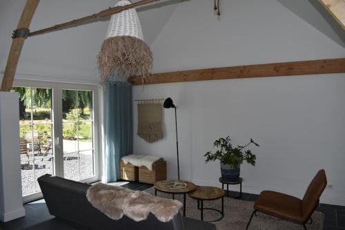 ein Wohnzimmer mit einem Sofa und einem Tisch in der Unterkunft Cosy Cott, een verborgen logeerplek in het landelijke Poeke. in Aalter