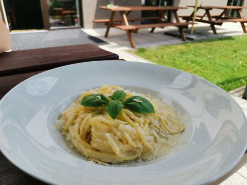 un plato blanco de pasta con albahaca en la parte superior en Penzion Garden, en Černý Důl