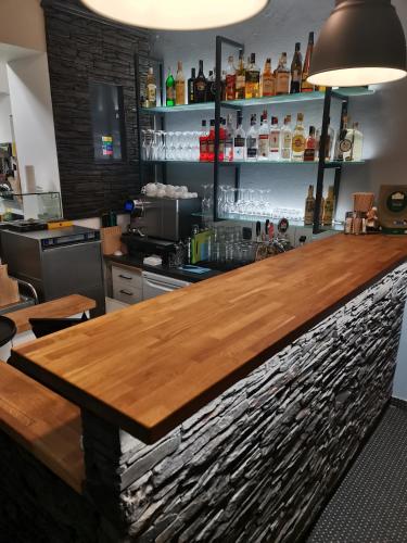 a bar with a wooden counter in a room at Penzion Garden in Cerny Dul