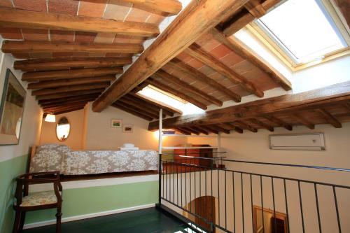 a living room with wooden ceilings and a bench in a room at Fabio Apartments San Gimignano in San Gimignano