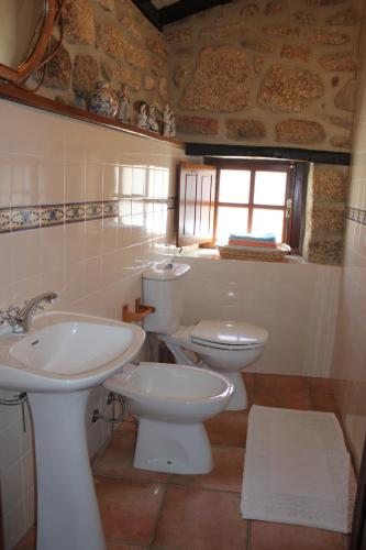 a bathroom with a sink and a toilet and a window at Casa do Balcao in Castelo Novo