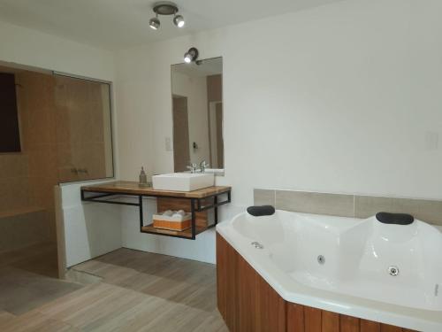 a bathroom with a white tub and a sink at InterLaken Apart & Suites in Villa Carlos Paz