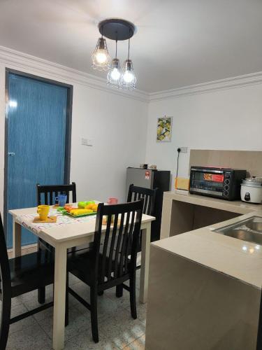 a kitchen with a table and chairs and a table and a kitchen with a counter at Sunrise Bedrooms and Transit in Ranau