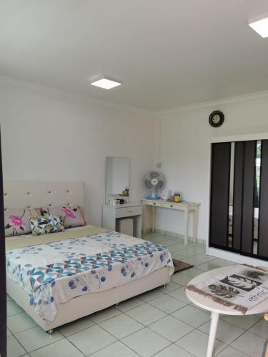 a bedroom with a bed and a table in it at Sunrise Bedrooms and Transit in Ranau