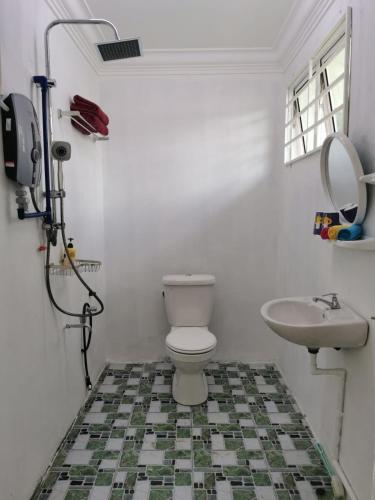 a bathroom with a toilet and a sink at Sunrise Bedrooms and Transit in Ranau