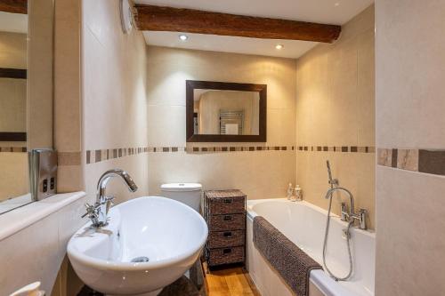 uma casa de banho com um lavatório e uma banheira em Bilberry Bank Cottage em Holmfirth