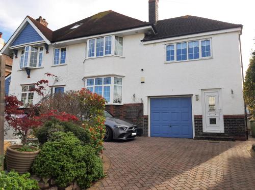 una casa bianca con un garage blu di Estuary view a Exmouth