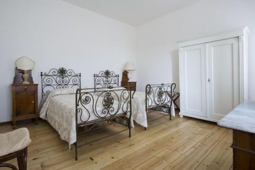 a white bedroom with a bed and two chairs at Casa Sincielli in Caorle
