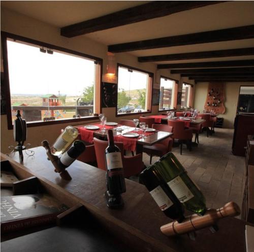un restaurante con mesas y sillas y botellas de vino en Flat em Gravatá Monte Castelo, en Gravatá