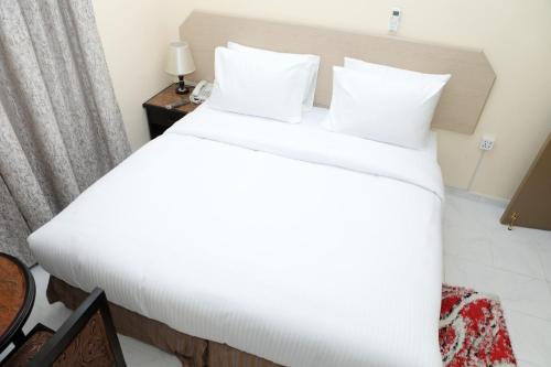 a large white bed in a hotel room at Blue Sky Way Hotel in Dubai