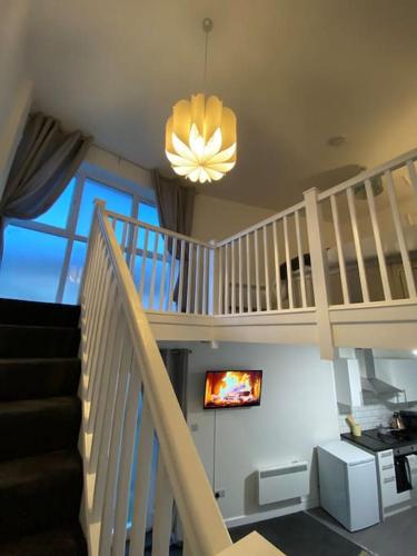 a living room with a staircase and a tv at Lodge in Plymouth