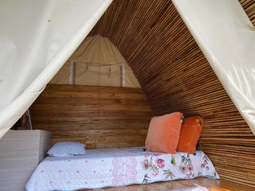 Una cama en una tienda con almohadas. en Esquipulas Rainforest, en Quepos