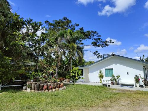 a white house with trees in the yard at Sunrise Bedrooms and Transit in Ranau