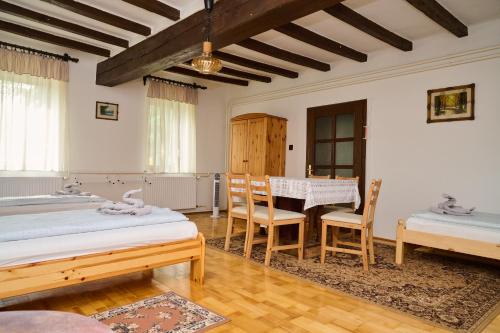 1 dormitorio con 2 camas, mesa y sillas en Kölcsey Vendégház, en Hódmezővásárhely