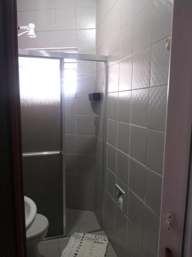 uma casa de banho com um chuveiro, um WC e um lavatório. em Casa Praia Piscina ITANHAÉM em Itanhaém