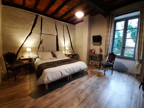 1 dormitorio con 1 cama grande y 2 sillas en Maison d'hôtes De La Boissière, en Andillac