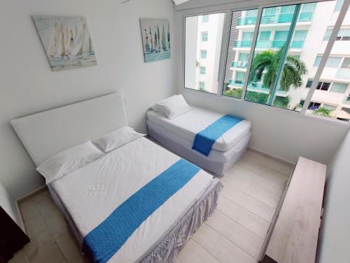 a small room with two beds and a window at Apartamento con vista al mar in Cartagena de Indias